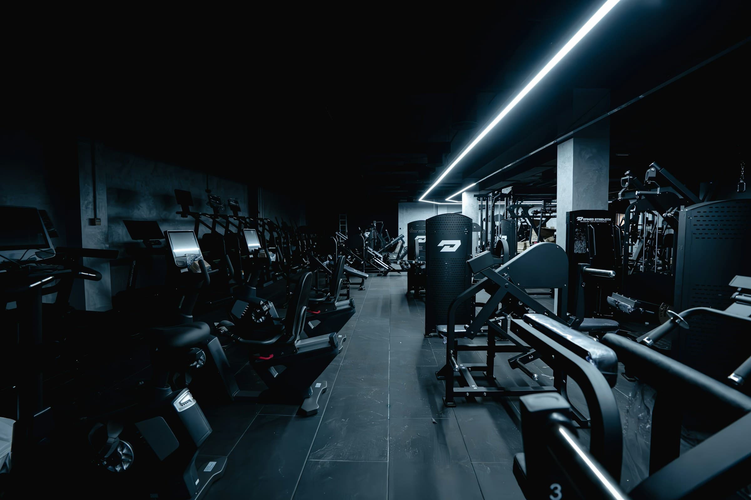 Dark modern gym with training equipment and cool LED lighting